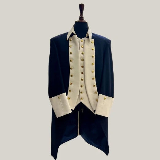 A formal historical-style coat with a dark navy blue body, cream-colored vest and cuffs, and gold buttons, displayed on a black mannequin torso against a solid light gray background.